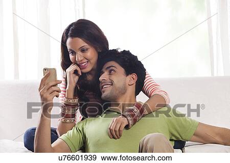 Stock Photo - Woman reading an sms on a mobile phone. Fotosearch
