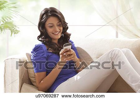 Woman reading an sms on a mobile phone View Large Photo Image Stock Photo - Woman reading an sms on a mobile phone. Fotosearch