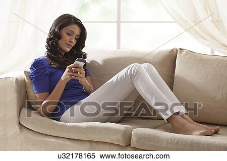 Stock Photography - Woman reading an sms on a mobile phone. Fotosearch