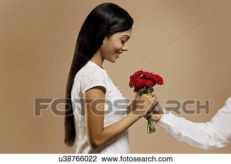 Stock Image - Woman receiving flowers from a man . Fotosearch