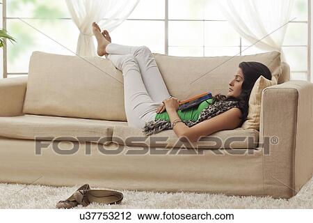 Woman resting on a sofa View Large Photo Image Stock Image - Woman resting on a sofa. Fotosearch