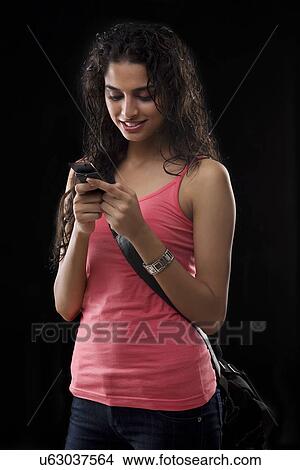 Picture - Woman sending a message on her mobile phone . Fotosearch