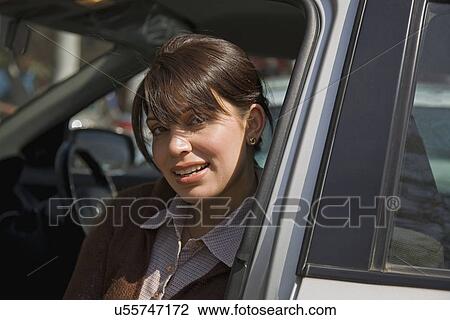Stock Image - Woman sitting inside the car . Fotosearch