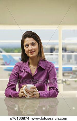 Picture - Woman sitting with a cup of coffee . Fotosearch