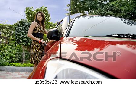 Woman standing next to a car View Large Photo Image Stock Image - Woman standing next to a car . Fotosearch
