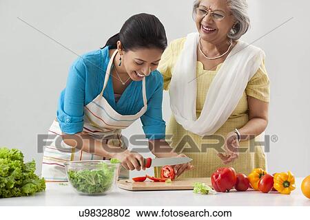 Woman teaching granddaughter how to cut tomato View Large Photo Image Stock Image - Woman teaching granddaughter how to cut tomato. Fotosearch