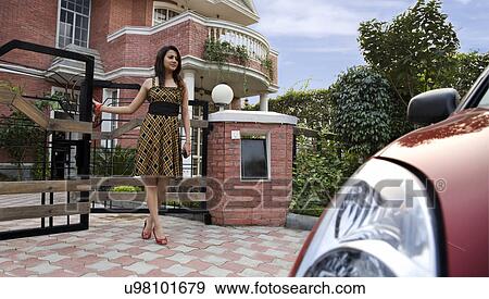 Stock Photo - Woman walking out of the gate . Fotosearch