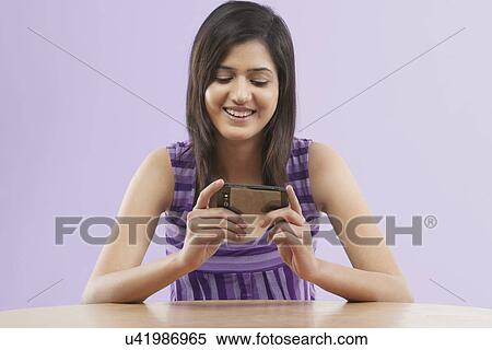 Woman watching a movie on a mobile phone View Large Photo Image Stock Photography - Woman watching a movie on a mobile phone . Fotosearch