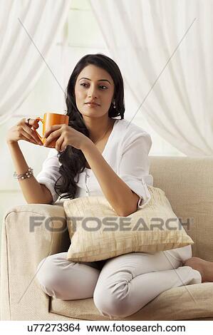Picture - Woman with a mug of tea thinking. Fotosearch