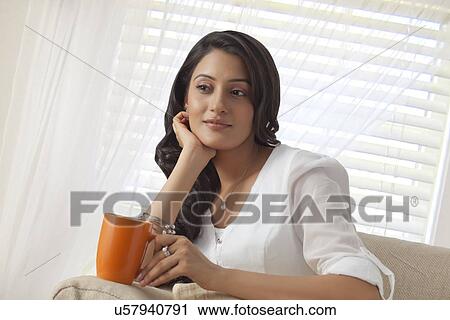 Woman with a mug of tea thinking View Large Photo Image Stock Image - Woman with a mug of tea thinking. Fotosearch
