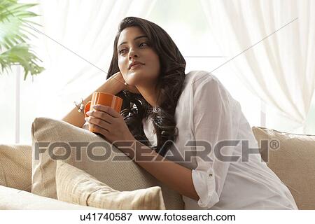 Stock Photo - Woman with a mug of tea thinking. Fotosearch