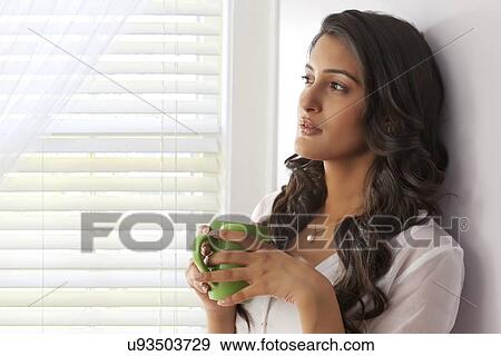 Woman with a mug of tea thinking View Large Photo Image Stock Photo - Woman with a mug of tea thinking. Fotosearch