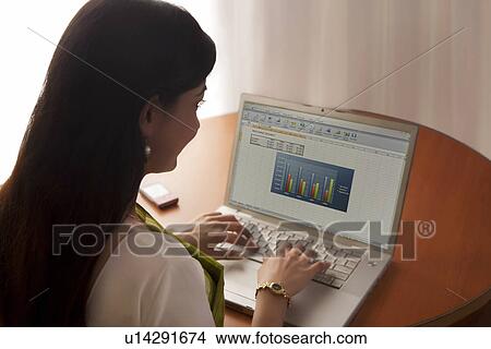 Woman working on a laptop View Large Photo Image Picture - Woman working on a laptop . Fotosearch