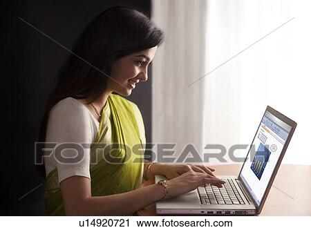 Woman working on a laptop View Large Photo Image Stock Image - Woman working on a laptop . Fotosearch