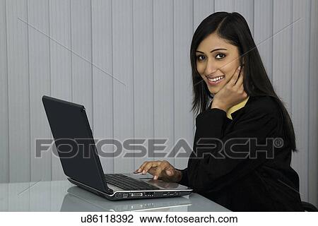 Woman working on a laptop View Large Photo Image Stock Image - Woman working on a laptop . Fotosearch