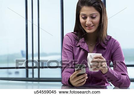Stock Photography - Women reading a message on a mobile phone . Fotosearch