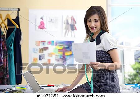 Young beautiful fashion designer using laptop in studio View Large Photo Image Stock Image - Young beautiful fashion designer using laptop in studio . Fotosearch