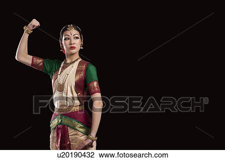 Young Bharatanatyam dancer flexing muscle over black background View Large Photo Image Stock Image - Young Bharatanatyam dancer flexing muscle over black background. Fotosearch