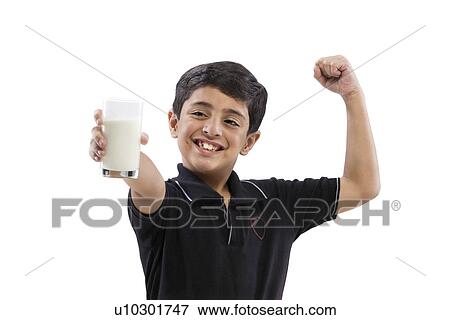 Young boy flexing his arm while holding a glass of milk View Large Photo Image Stock Photo - Young boy flexing his arm while holding a glass of milk . Fotosearch