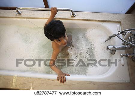 Stock Photo - Young boy having a bubble bath . Fotosearch