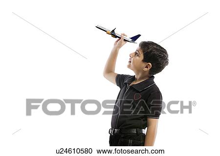Stock Image - Young boy holding a model of a plane . Fotosearch