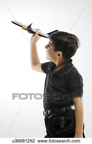 Young boy holding a model of a plane View Large Photo Image Stock Image - Young boy holding a model of a plane . Fotosearch
