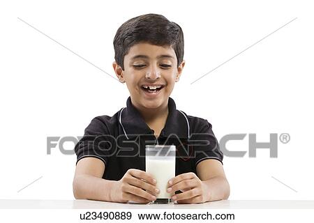 Stock Photo - Young boy looking at a glass of milk . Fotosearch