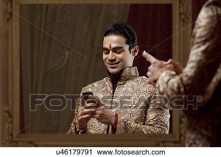 Young bridegroom text messaging in traditional outfit while using mobile phone View Large Photo Image Stock Image - Young bridegroom text messaging in traditional outfit while using mobile phone . Fotosearch