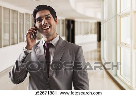 Young business man having conversation on call View Large Photo Image Stock Image - Young business man having conversation on call . Fotosearch