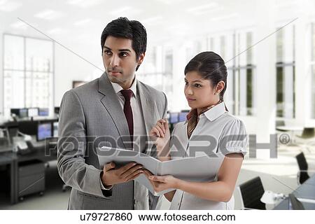 Young business people looking away while holding document View Large Photo Image Stock Image - Young business people looking away while holding document . Fotosearch