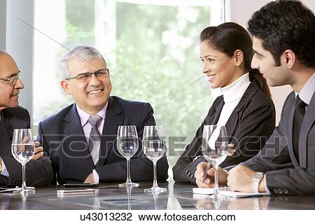 Young business professionals sitting with senior male executives in office View Large Photo Image Stock Image - Young business professionals sitting with senior male executives in office . Fotosearch