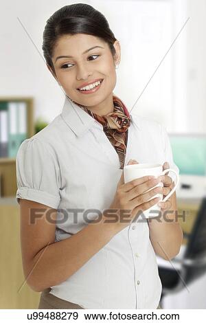 Stock Photo - Young businesswoman taking a coffee break from her busy schedule . Fotosearch