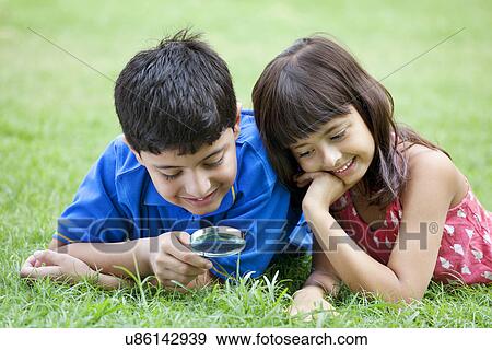 Young children with magnifying glass View Large Photo Image Stock Photo - Young children with magnifying glass . Fotosearch