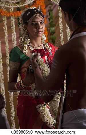 Stock Image - Young couple holding garlands . Fotosearch