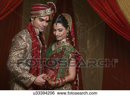 Stock Photograph - Young couple holding hands and looking down . Fotosearch