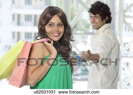 Stock Image - Young couple holding hands while shopping . Fotosearch