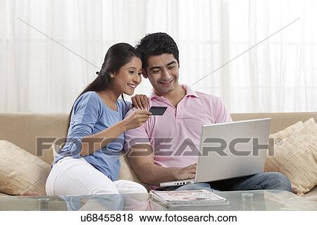 Young couple shopping online at home View Large Photo Image Stock Photo - Young couple shopping online at home . Fotosearch