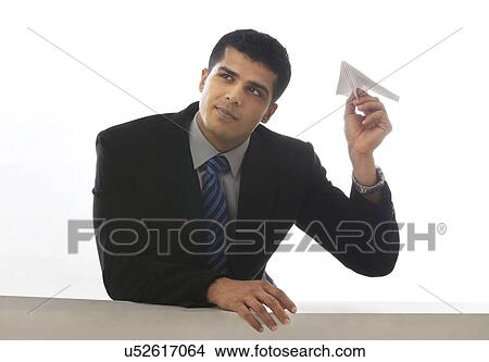 Picture - Young executive about to toss a paper airplane . Fotosearch