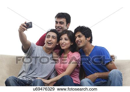 Young friends taking self picture over white background View Large Photo Image Stock Photo - Young friends taking self picture over white background . Fotosearch