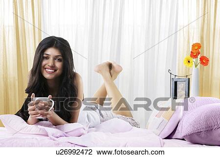 Young girl in bed with a cup of coffee View Large Photo Image Stock Image - Young girl in bed with a cup of coffee . Fotosearch