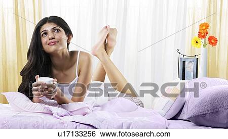 Young girl in bed with a cup of coffee View Large Photo Image Stock Photograph - Young girl in bed with a cup of coffee . Fotosearch