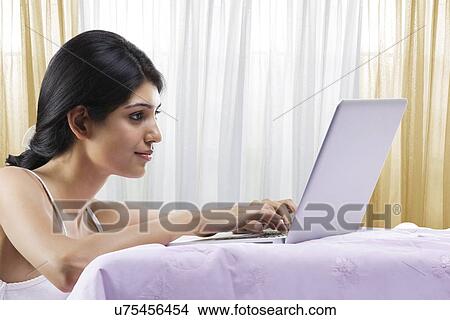 Young girl working on a laptop View Large Photo Image Picture - Young girl working on a laptop . Fotosearch