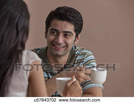 Young handsome man having hot drink with woman View Large Photo Image Stock Image - Young handsome man having hot drink with woman . Fotosearch