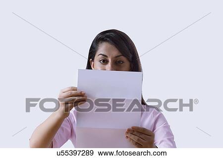 Stock Photo - Young Indian businesswoman reading document over white background. Fotosearch
