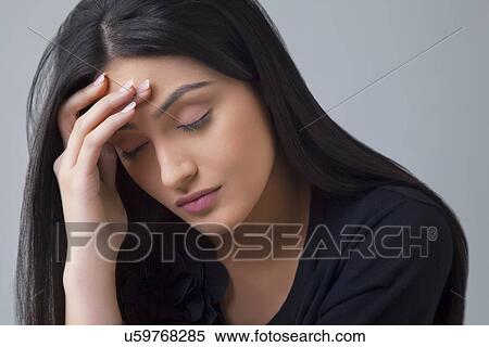 Young Indian woman suffering from headache isolated over colored background View Large Photo Image Stock Photography - Young Indian woman suffering from headache isolated over colored background . Fotosearch