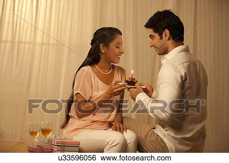 Young loving man giving cake to woman at home View Large Photo Image Stock Photograph - Young loving man giving cake to woman at home . Fotosearch