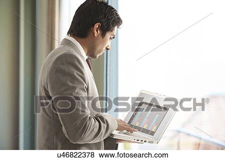 Young male executive using laptop for business purpose View Large Photo Image Stock Photo - Young male executive using laptop for business purpose . Fotosearch