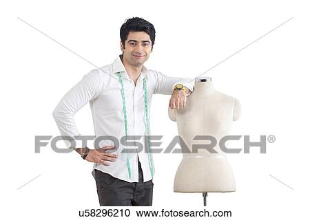 Young male fashion designer standing by mannequin over white background View Large Photo Image Stock Image - Young male fashion designer standing by mannequin over white background . Fotosearch