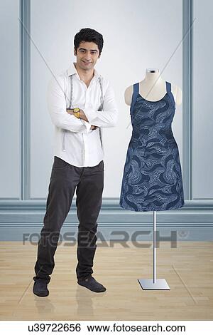 Young male fashion designer standing by mannequin at studio View Large Photo Image Stock Photograph - Young male fashion designer standing by mannequin at studio . Fotosearch