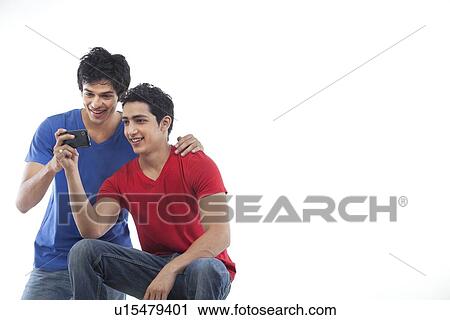 Young male friends watching video on the phone over white background View Large Photo Image Stock Image - Young male friends watching video on the phone over white background . Fotosearch